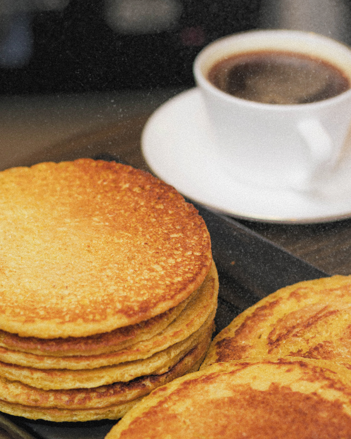 Arepas de choclo apiladas con café negro
