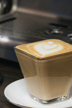 Latte con arte en vaso de vidrio