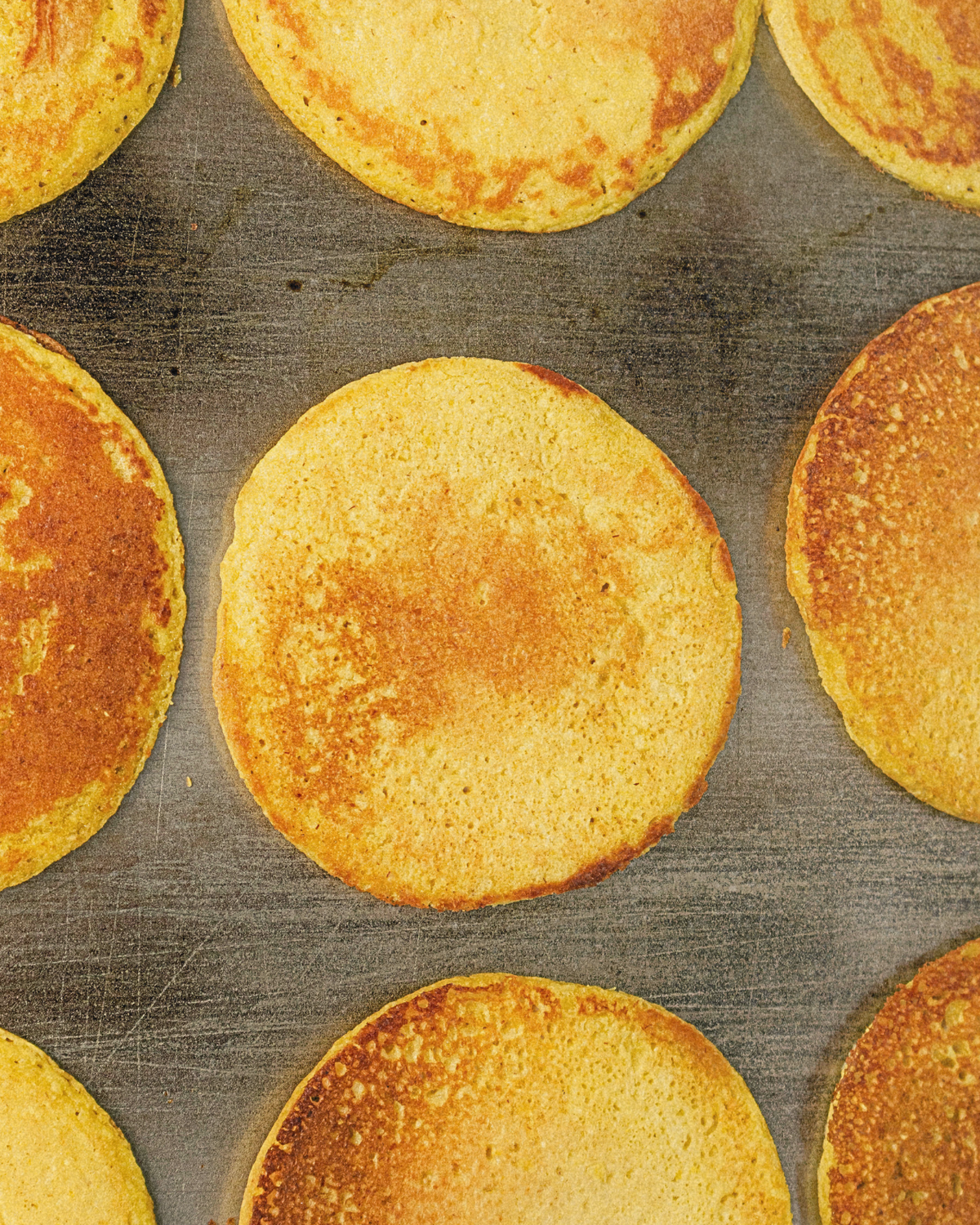 Arepas de choclo dorándose en la plancha