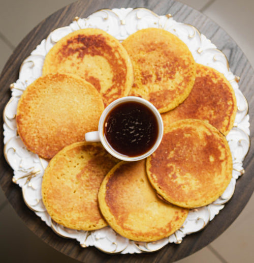 Plato de arepas de choclo con café