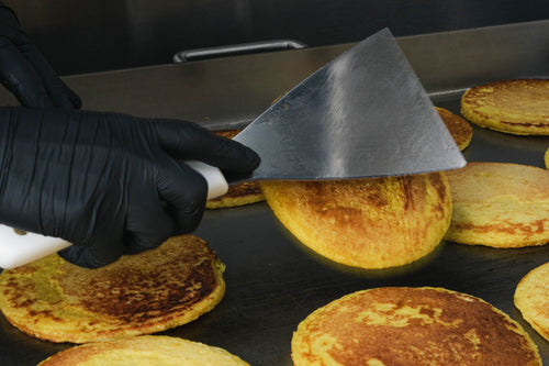 Volteando la arepa de choclo en la plancha